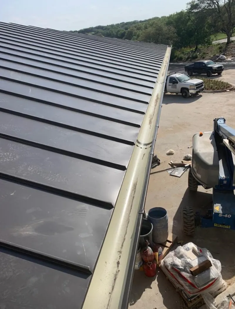 Standing seam panel and gutter detail on a metal roofing jobsite in Jasmine Estates